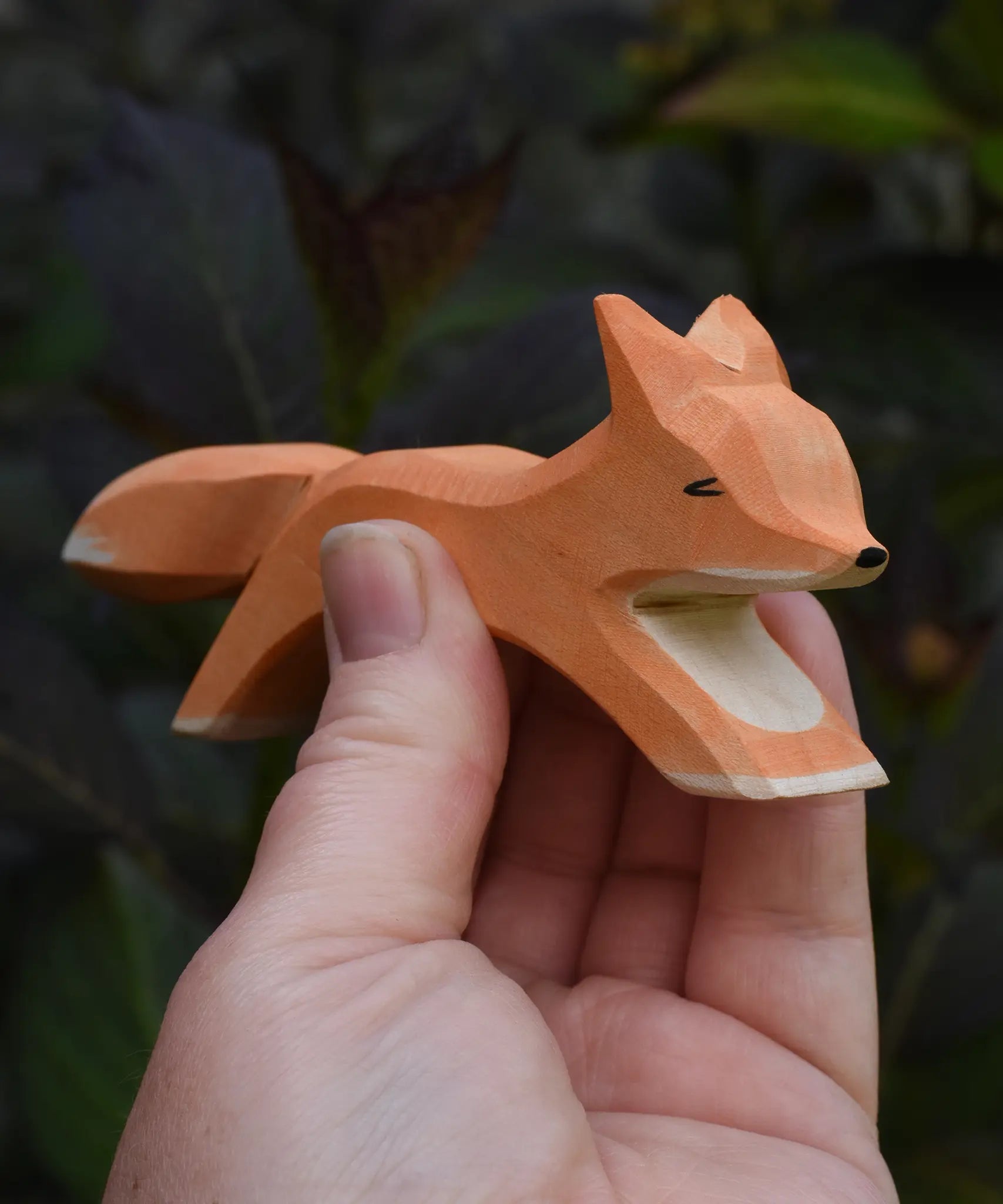 Ostheimer running fox wooden toy figure in an adult's hand.