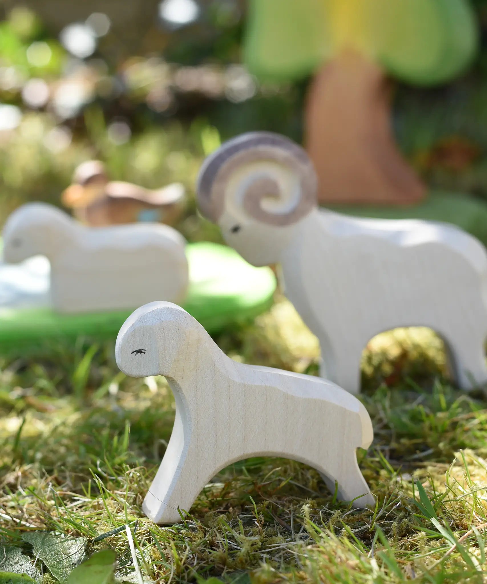 Ostheimer running lamb wooden toy figure placed on grass in the Babipur garden. 