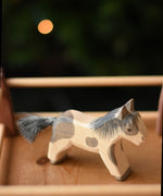 An Ostheimer shetland pony wooden toy figure placed in a pen created with Ostheimer wooden fence pieces.  Ostheimer's range of hand crafted, heirloom quality wooden toys are available to buy at Babipur. 