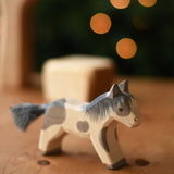An Ostheimer shetland pony wooden toy figure placed on a wooden surface.  Ostheimer's range of hand crafted, heirloom quality wooden toys are available to buy at Babipur. 