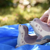 Ostheimer sea lion head high placed on a blue Laura's cotton play cloth on the Babipur garden. Child holding another sea lion in their hand.