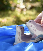 Ostheimer sea lion head high placed on a blue Laura's cotton play cloth on the Babipur garden. Child holding another sea lion in their hand.