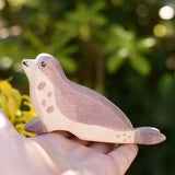 Ostheimer sea lion wooden toy figure with it's had low in an adult's hand.