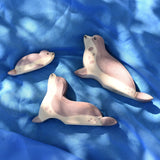 Ostheimer wooden sea lion toy figures placed on a blue Laura's cotton play cloth in the Babipur garden.