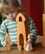 Child playing with the Ostheimer castle sentry post building with bell with the princess and frog king in front.