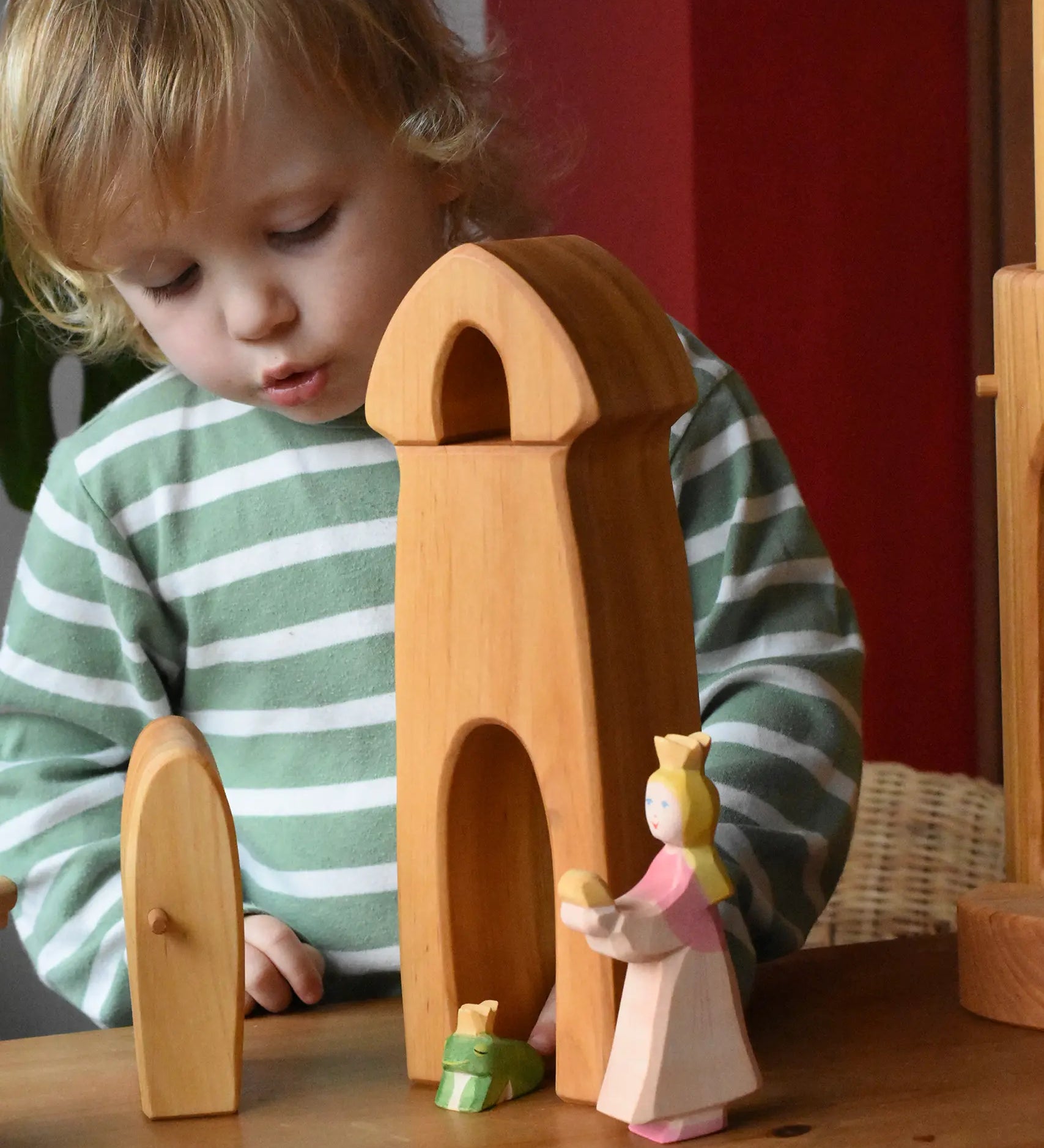Child playing with the Ostheimer castle sentry post building with bell with the princess and frog king in front.