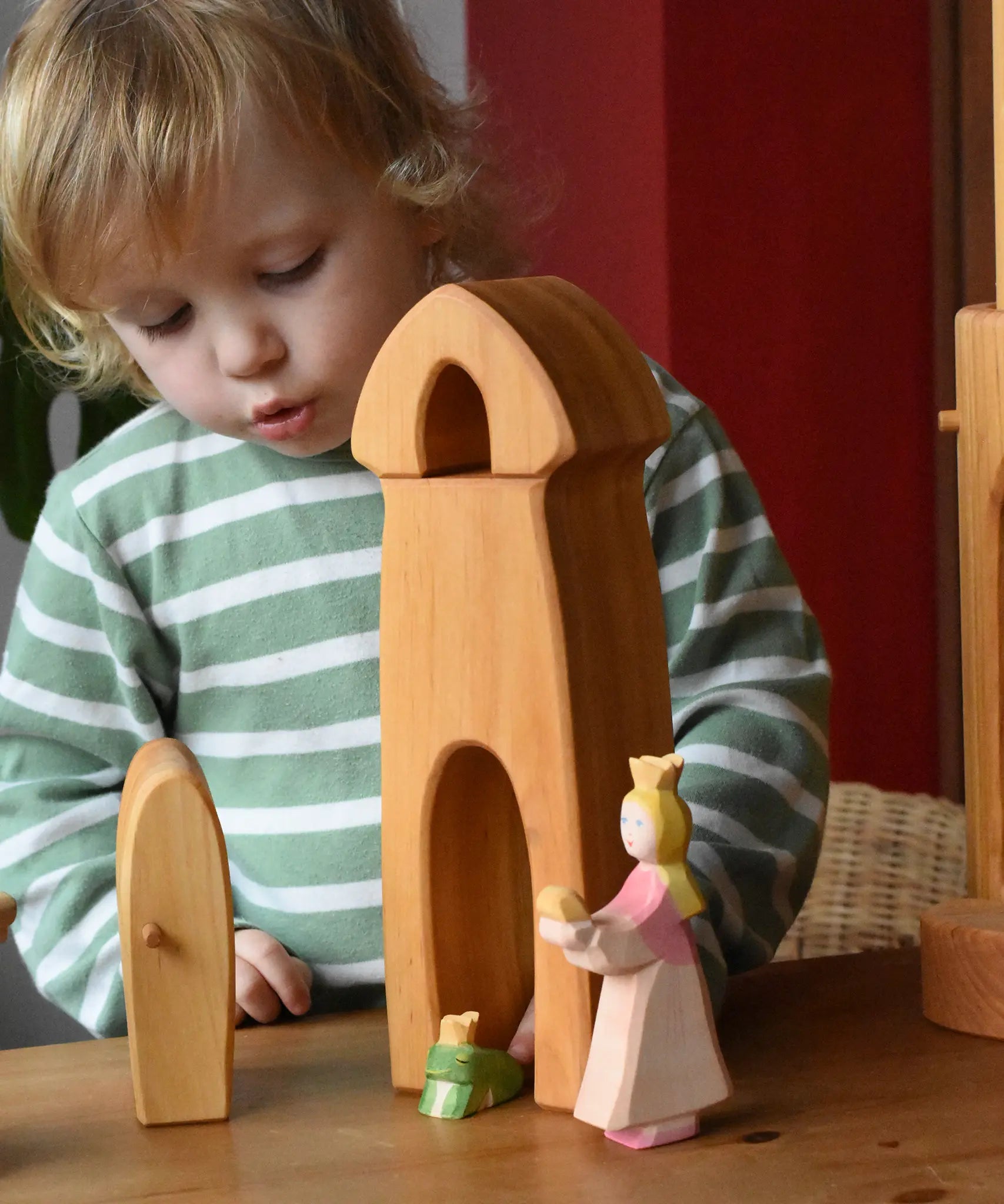 Child playing with the Ostheimer castle sentry post building with bell with the princess and frog king in front.