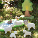 Ostheimer small world play scene with lamb, sheep, ram and duck  wooden toy figures placed on grass in the Babipur garden.