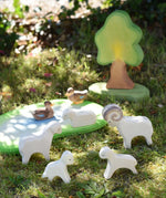 Ostheimer small world play scene with lamb, sheep, ram and duck  wooden toy figures placed on grass in the Babipur garden.