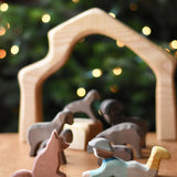 An Ostheimer shepherd's dog wooden toy figure and a lying shepherd figure placed on a wooden surface. These wooden figures are part of a wide range of expertly hand crafted wooden toys here at Babipur. 