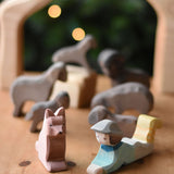 An Ostheimer shepherd's dog wooden toy figure and a lying shepherd figure placed on a wooden surface. These wooden figures are part of a wide range of expertly hand crafted wooden toys here at Babipur. 