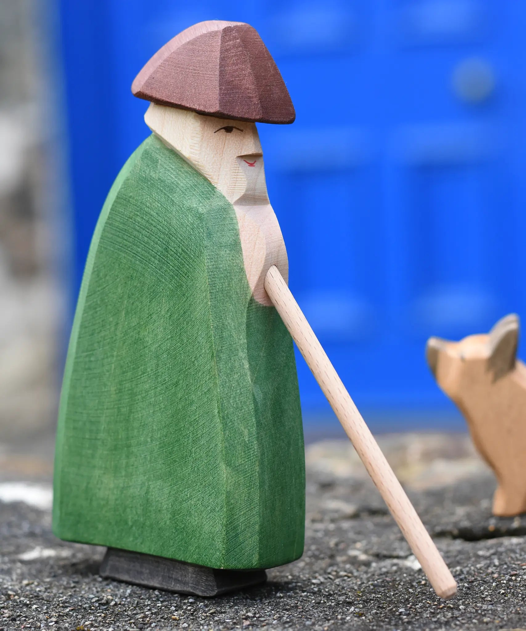 Ostheimer shepherd with staff placed on a stone wall outdoors.