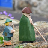 Ostheimer shepherd with staff next to a small shepherd boy placed on a stone wall outdoors. 