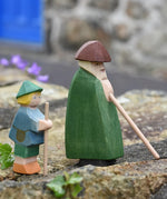 Ostheimer shepherd with staff next to a small shepherd boy placed on a stone wall outdoors. 