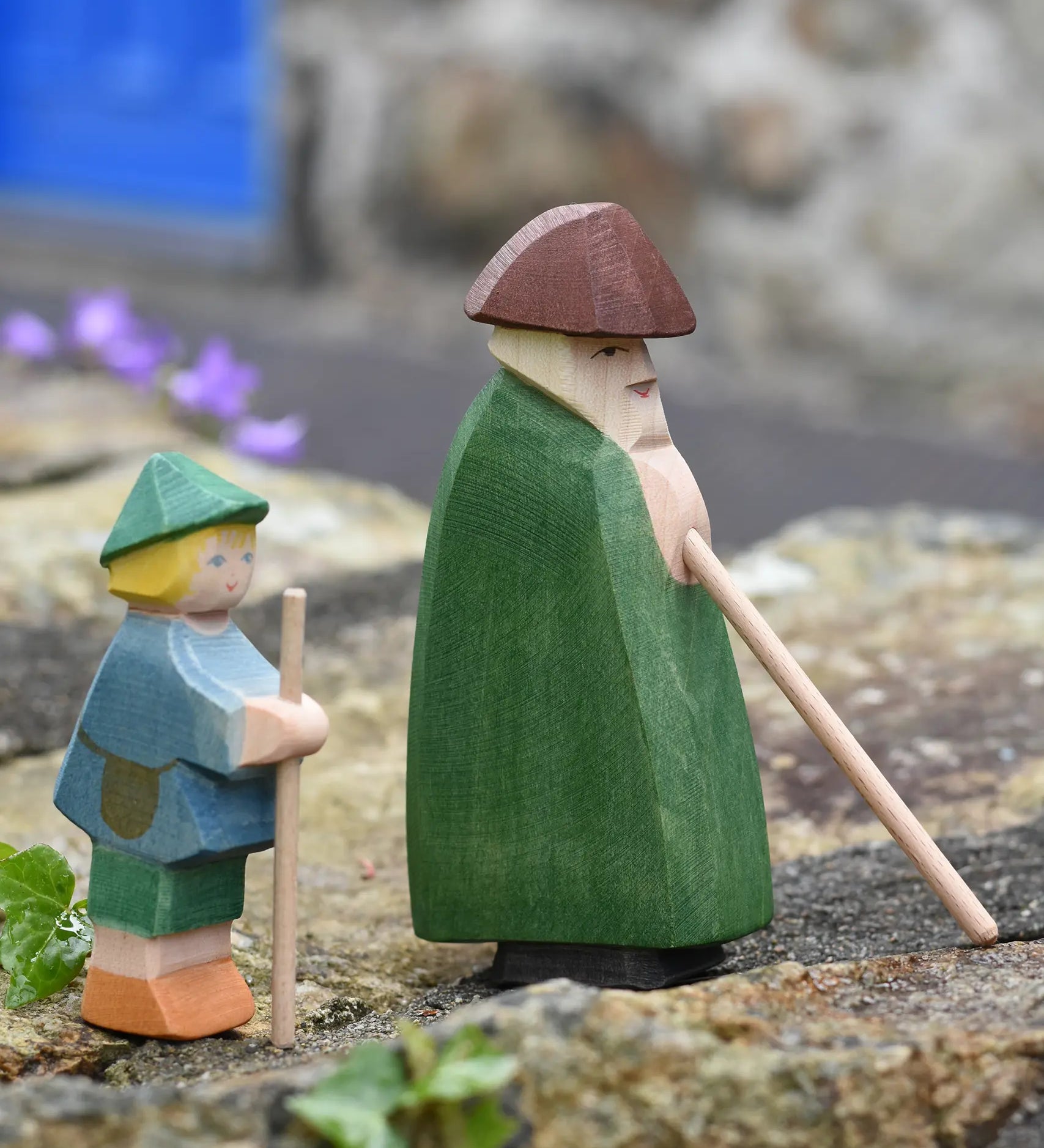 Ostheimer shepherd with staff next to a small shepherd boy placed on a stone wall outdoors. 