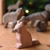 An Ostheimer shepherd's dog wooden toy figure placed on a wooden surface. These wooden figures are part of a wide range of expertly hand crafted wooden toys here at Babipur. 