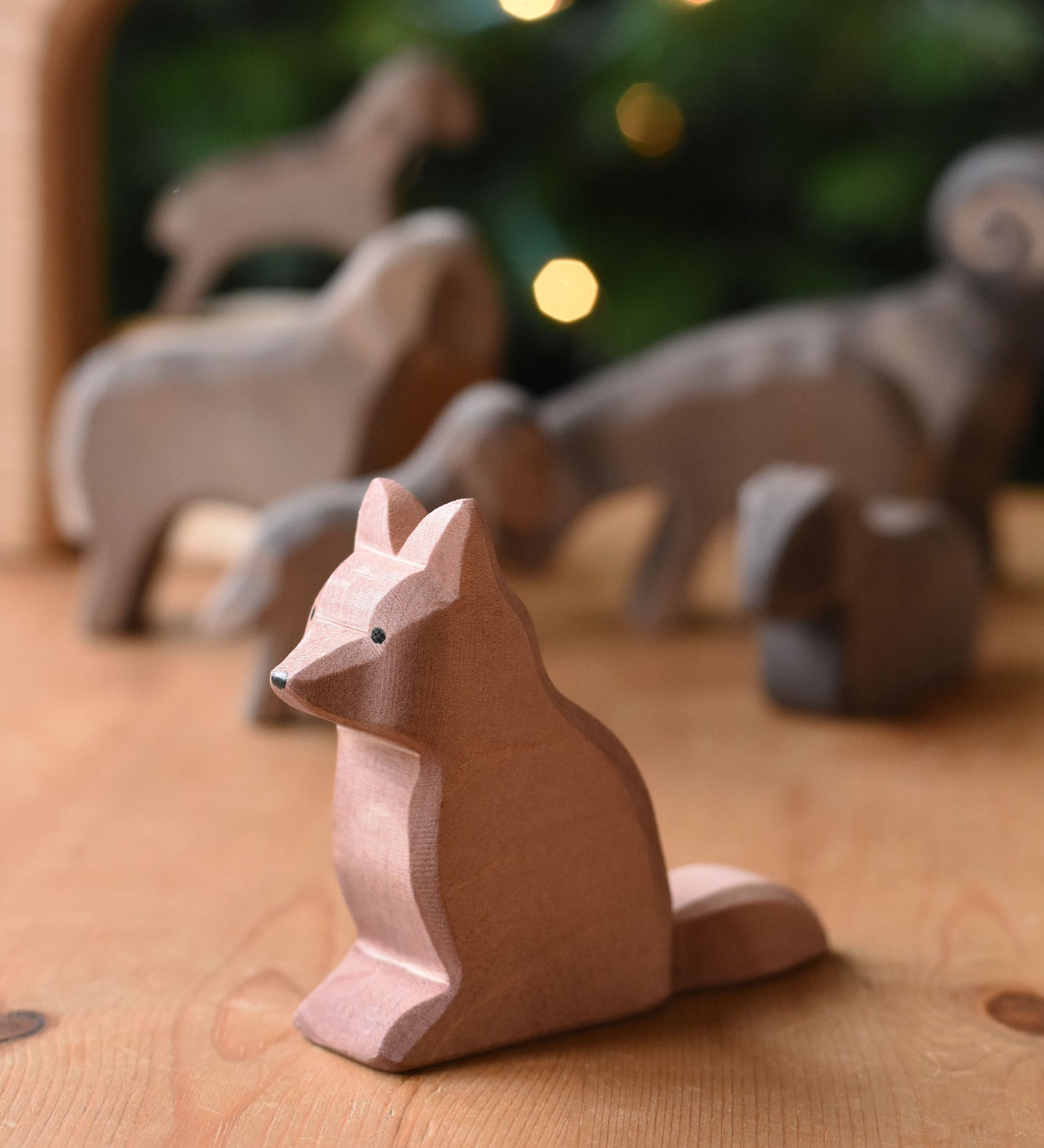 An Ostheimer shepherd's dog wooden toy figure placed on a wooden surface. These wooden figures are part of a wide range of expertly hand crafted wooden toys here at Babipur. 