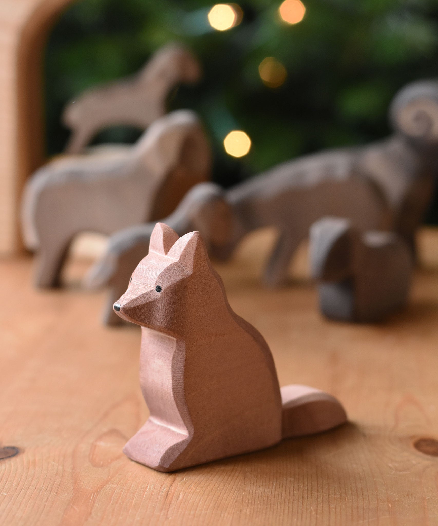 An Ostheimer shepherd's dog wooden toy figure placed on a wooden surface. These wooden figures are part of a wide range of expertly hand crafted wooden toys here at Babipur. 