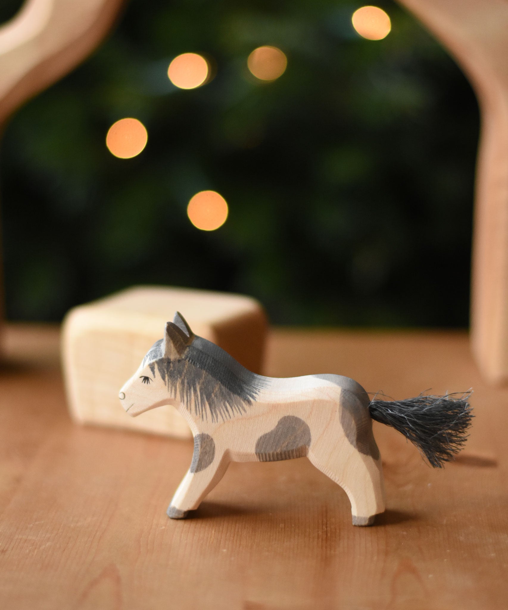 An Ostheimer shetland pony wooden toy figure placed on a wooden surface.  Ostheimer's range of hand crafted, heirloom quality wooden toys are available to buy at Babipur. 