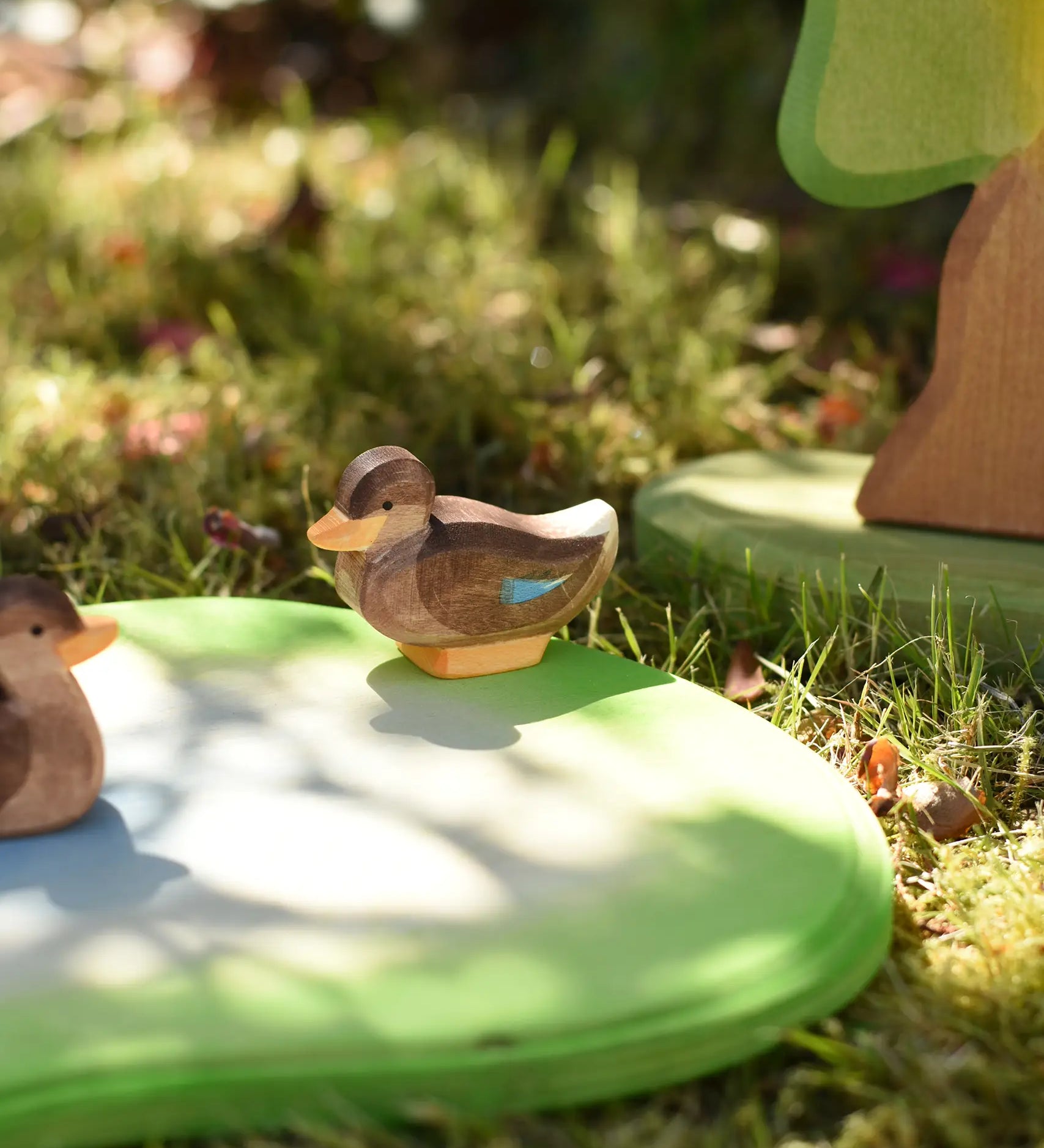Ostheimer sitting duck wooden toy figure placed on a pond piece in the Babipur garden. 