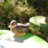 Ostheimer sitting duck wooden toy figure placed on a pond piece in the Babipur garden. 