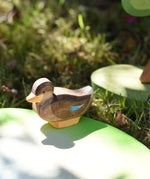 Ostheimer sitting duck wooden toy figure placed on a pond piece in the Babipur garden. 