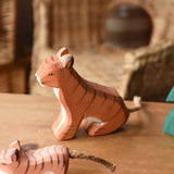 Ostheimer sitting tiger wooden toy figure placed on a wooden surface.