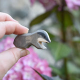 A small Ostheimer wooden toy badger figure shown in an adult's hand for scale. 
