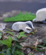 An Ostheimer small wooden badger figure placed on a stone wall outdoors. Check out our full range of wooden toy figures at Babipur.
