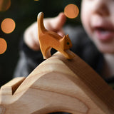 An Ostheimer small cat with low head placed on a house shaped wooden piece. These wooden figures are part of a wide range of expertly hand crafted wooden toys here at Babipur.
