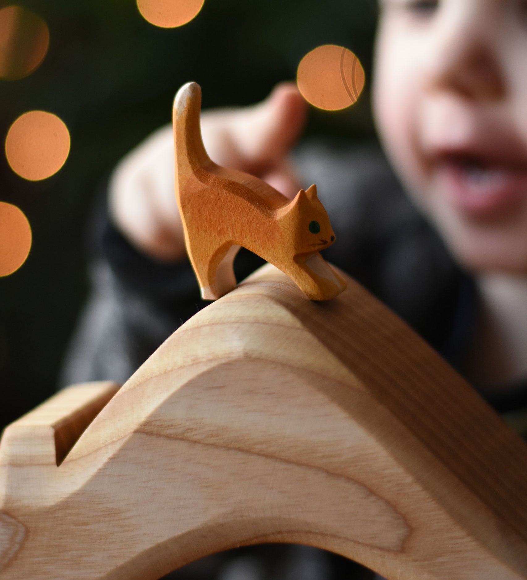 An Ostheimer small cat with low head placed on a house shaped wooden piece. These wooden figures are part of a wide range of expertly hand crafted wooden toys here at Babipur.