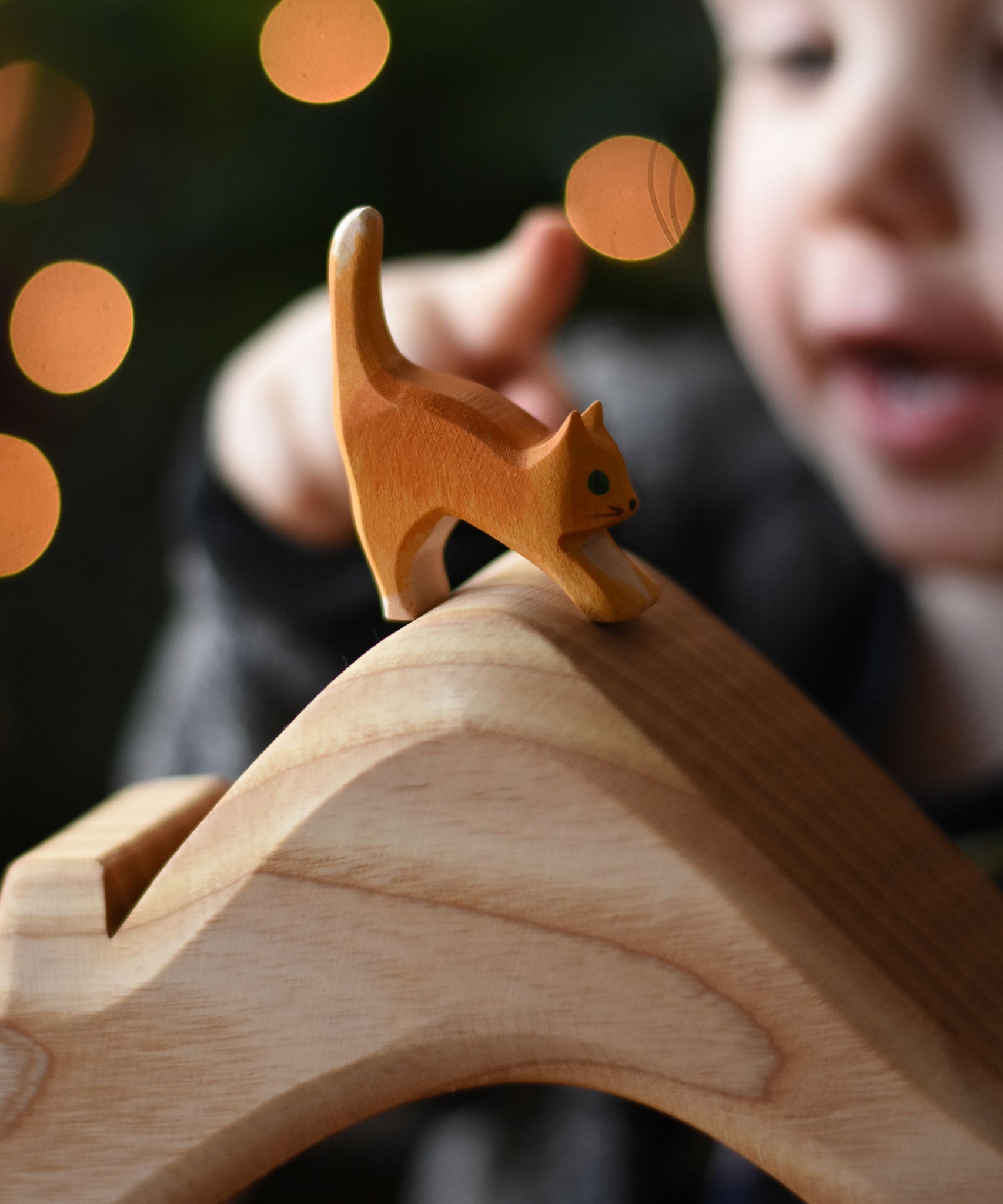 An Ostheimer small cat with low head placed on a house shaped wooden piece. These wooden figures are part of a wide range of expertly hand crafted wooden toys here at Babipur.