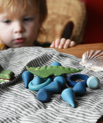 Small Ostheimer crocodile placed on a pile of blue coloured Grapat mandala pieces and rings.