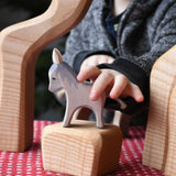 A child's hand reaching for the small Ostheimer donkey wooden toy figure.  Ostheimer's range of hand crafted, heirloom quality wooden toys are available to buy at Babipur. 