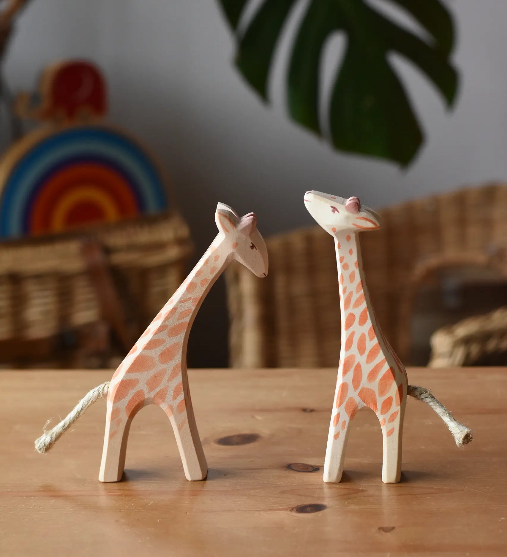 Ostheimer small giraffes wooden toy figures one with head low and one with head high placed next to each other.