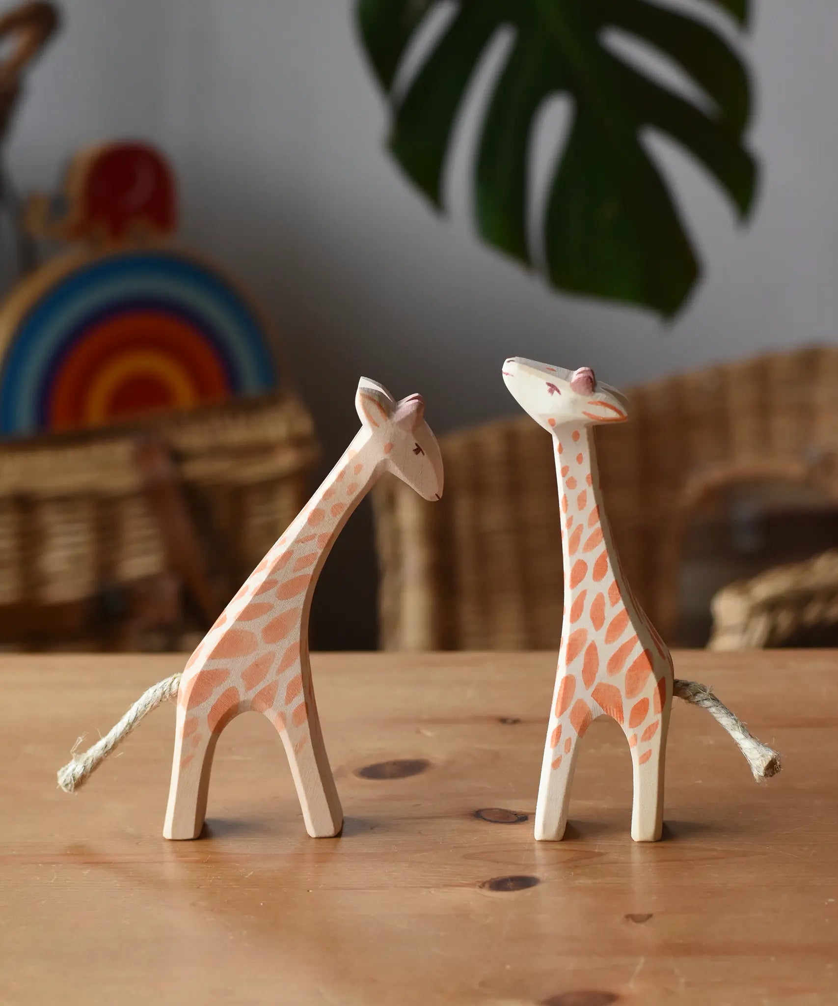 Ostheimer small giraffes wooden toy figures one with head low and one with head high placed next to each other.