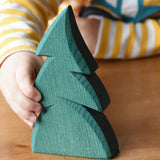 Child's hand reaching for the Ostheimer small green spruce tree. 