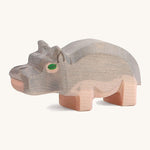 A small wooden Ostheimer hippo figure on a cream backround.