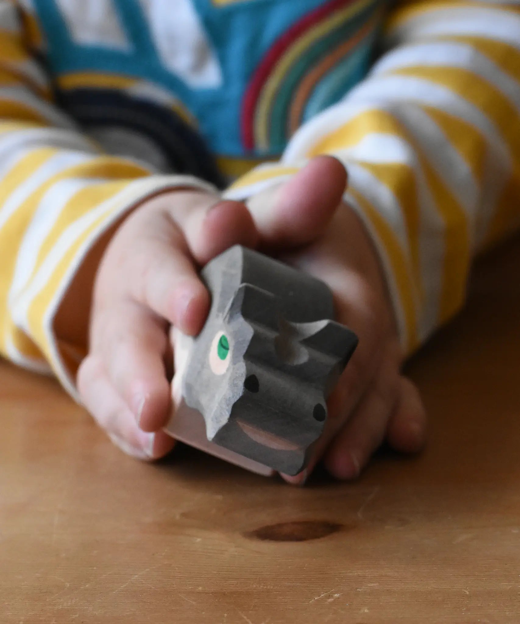 Ostheimer small hippopotamus wooden toy figure in a child's hand. 