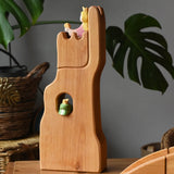 Ostheimer small wooden lookout tower wooden toy placed in a small world play scene with a princess in the tower and a frog king in the window. 