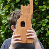 Child holding the Ostheimer small wooden lookout tower wooden toy up to their eye looking through the window.