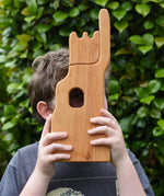 Child holding the Ostheimer small wooden lookout tower wooden toy up to their eye looking through the window.