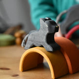 Ostheimer small black panther wooden toy figure placed on the yellow arch from the Grimm's mini rainbow. 