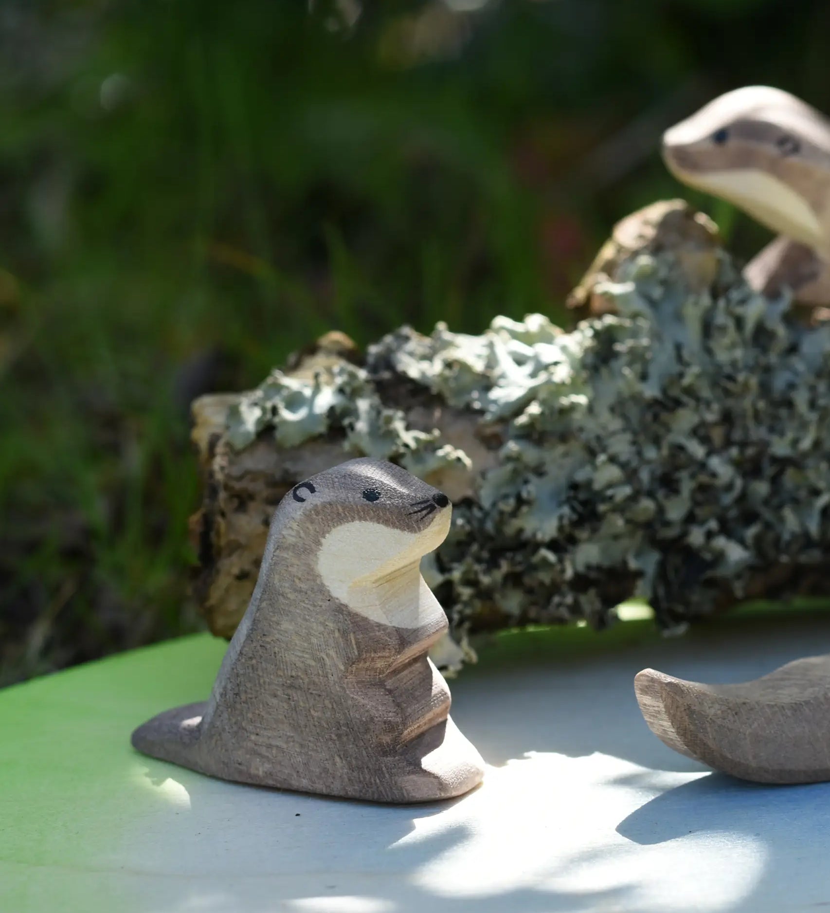 Ostheimer small  sea otter wooden toy figure placed on a pond play scenery piece in a small world play set up.