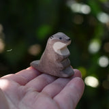 Ostheimer small sea otter wooden toy figure on an adult's hand.