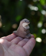 Ostheimer small sea otter wooden toy figure on an adult's hand.