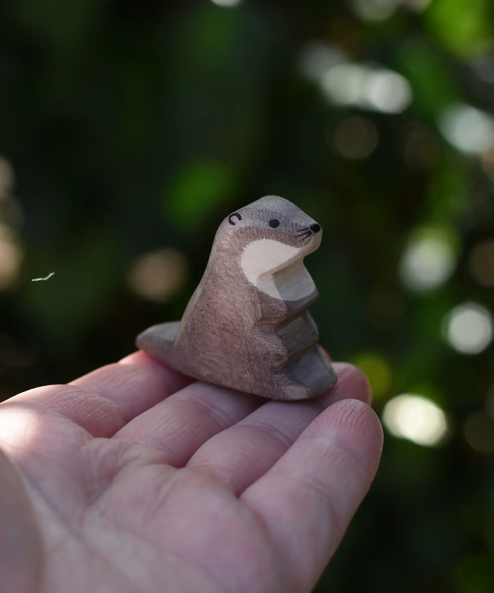 Ostheimer small sea otter wooden toy figure on an adult's hand.