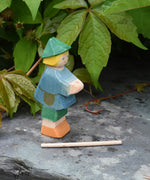 Ostheimer small shepherd boy wooden toy figure with his staff removed from the holder in his hands and placed on the slate in front of him.