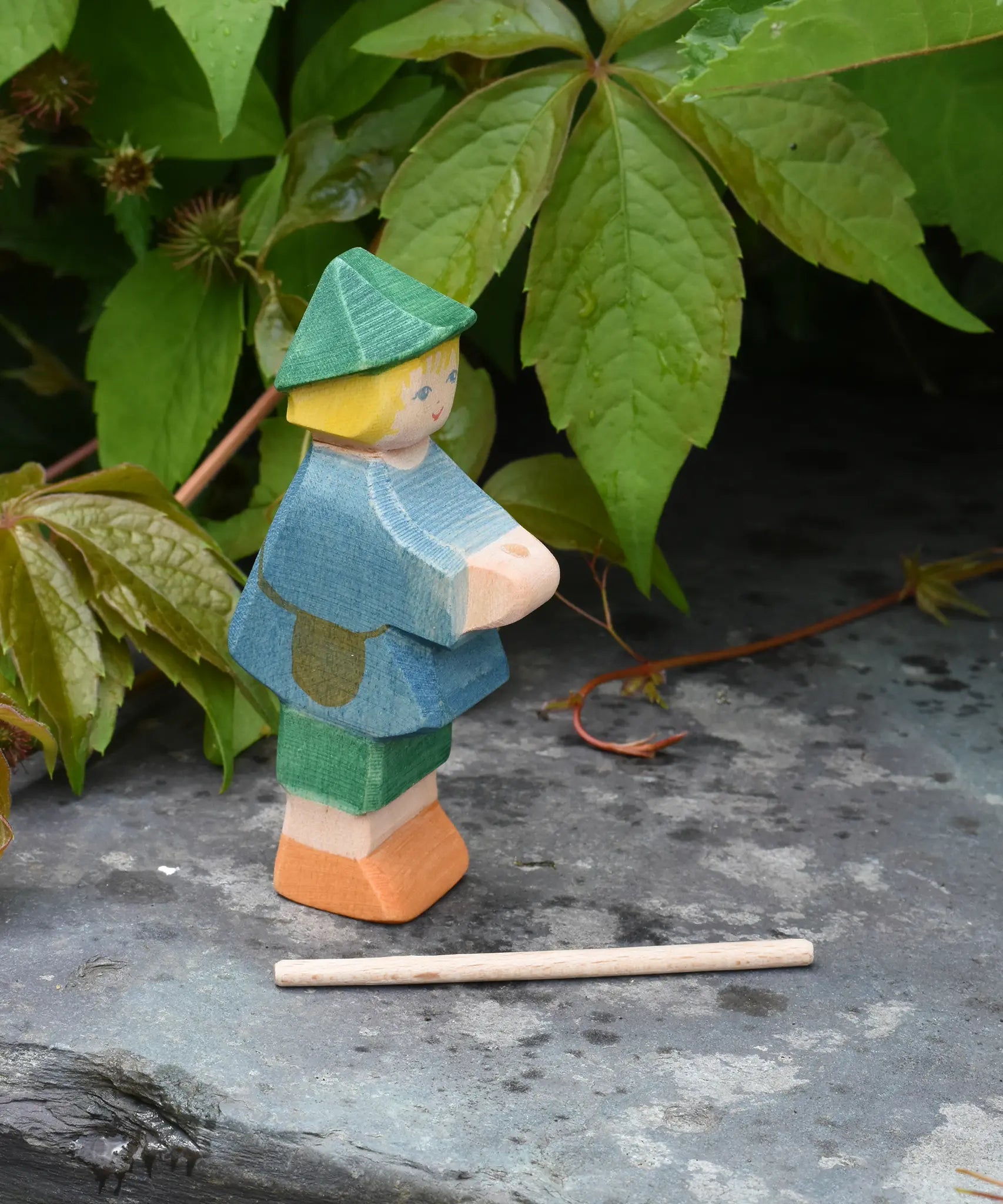 Ostheimer small shepherd boy wooden toy figure with his staff removed from the holder in his hands and placed on the slate in front of him.