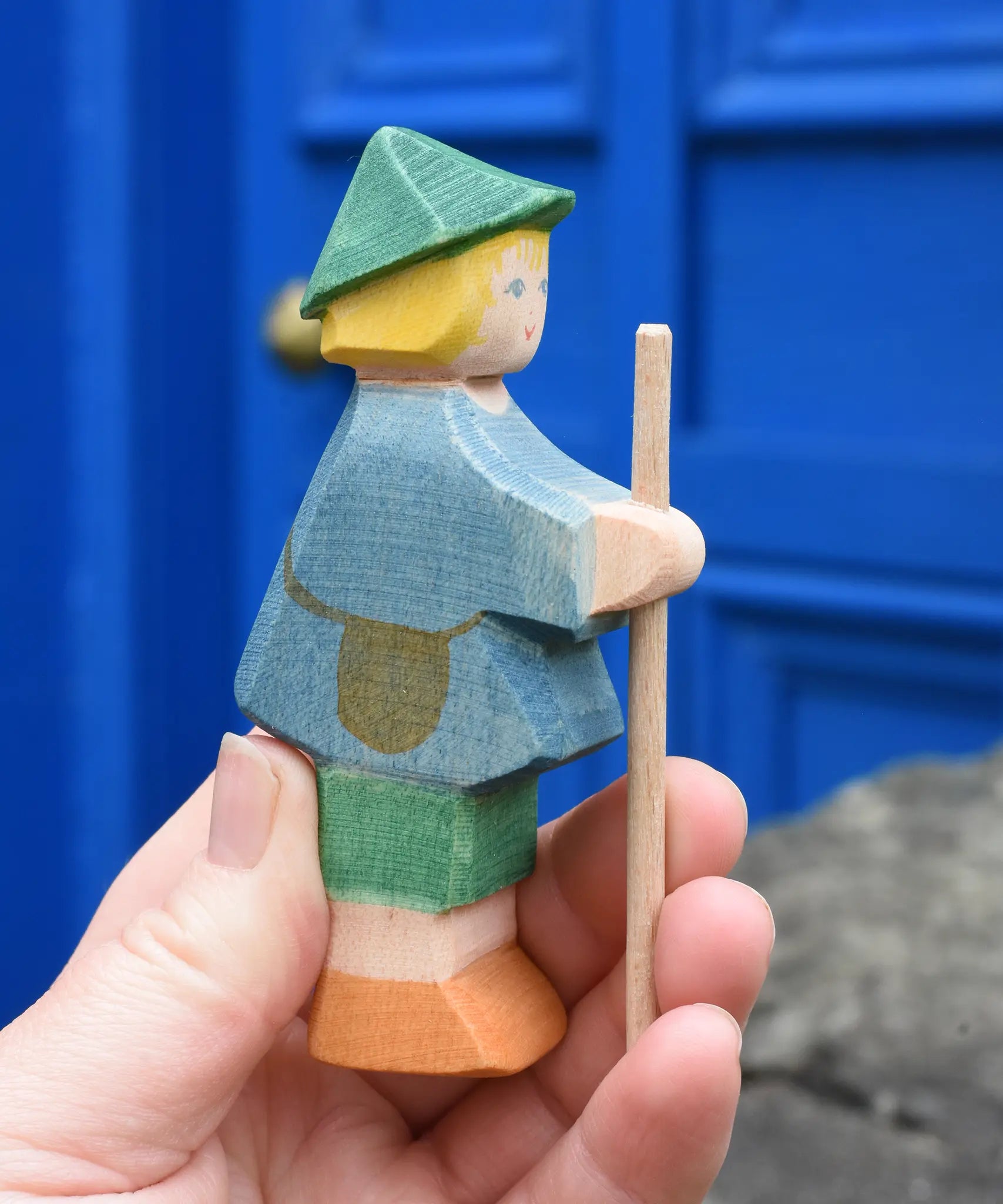 Ostheimer small shepherd boy wooden toy figure in an adult's hand.